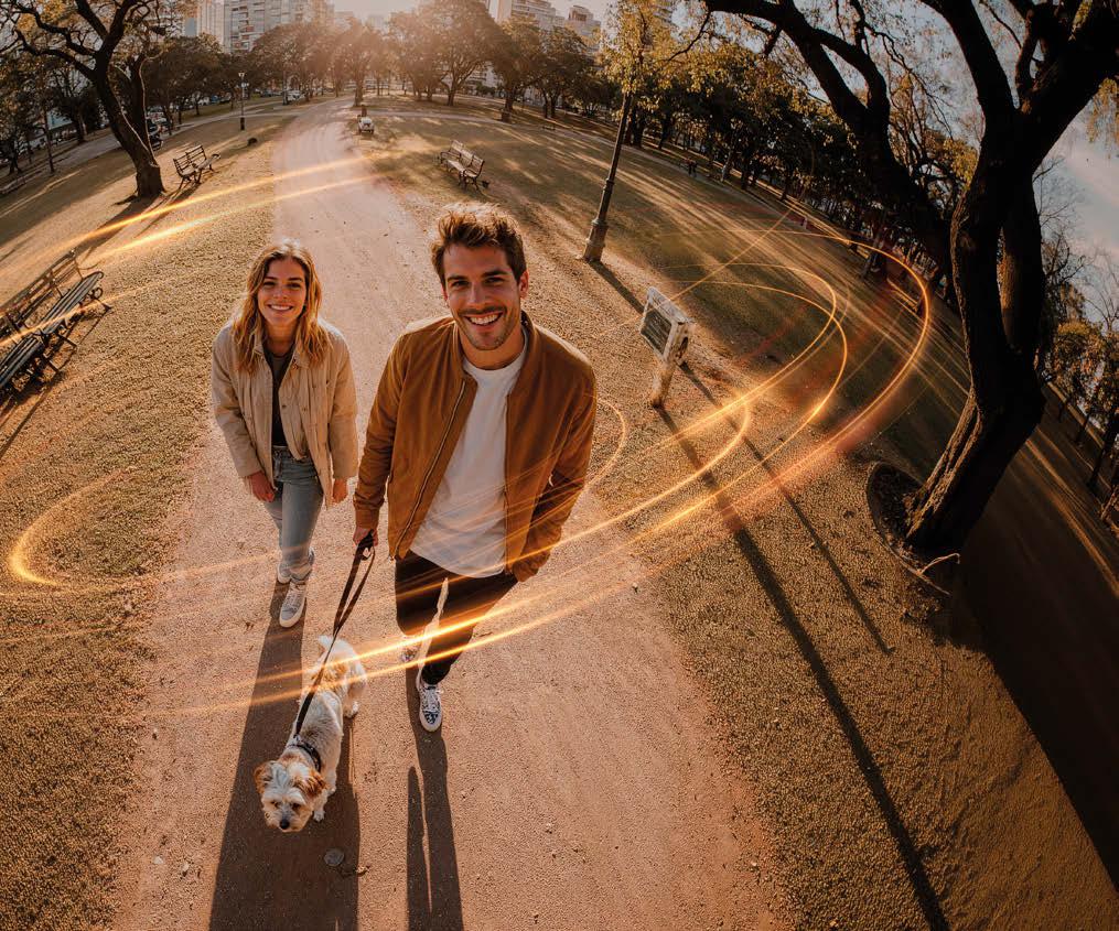 Casal caminhando em um parque com traços de luz dourada